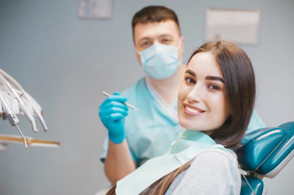 A dentist and patient smiling together