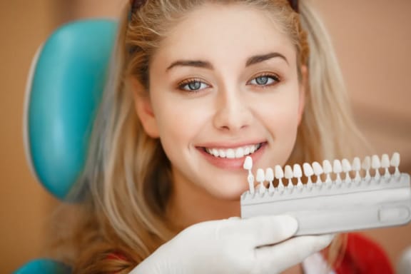 A dental provider matching a patient’s tooth shade