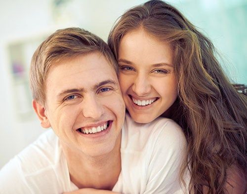 A smiling couple after dental implant treatment